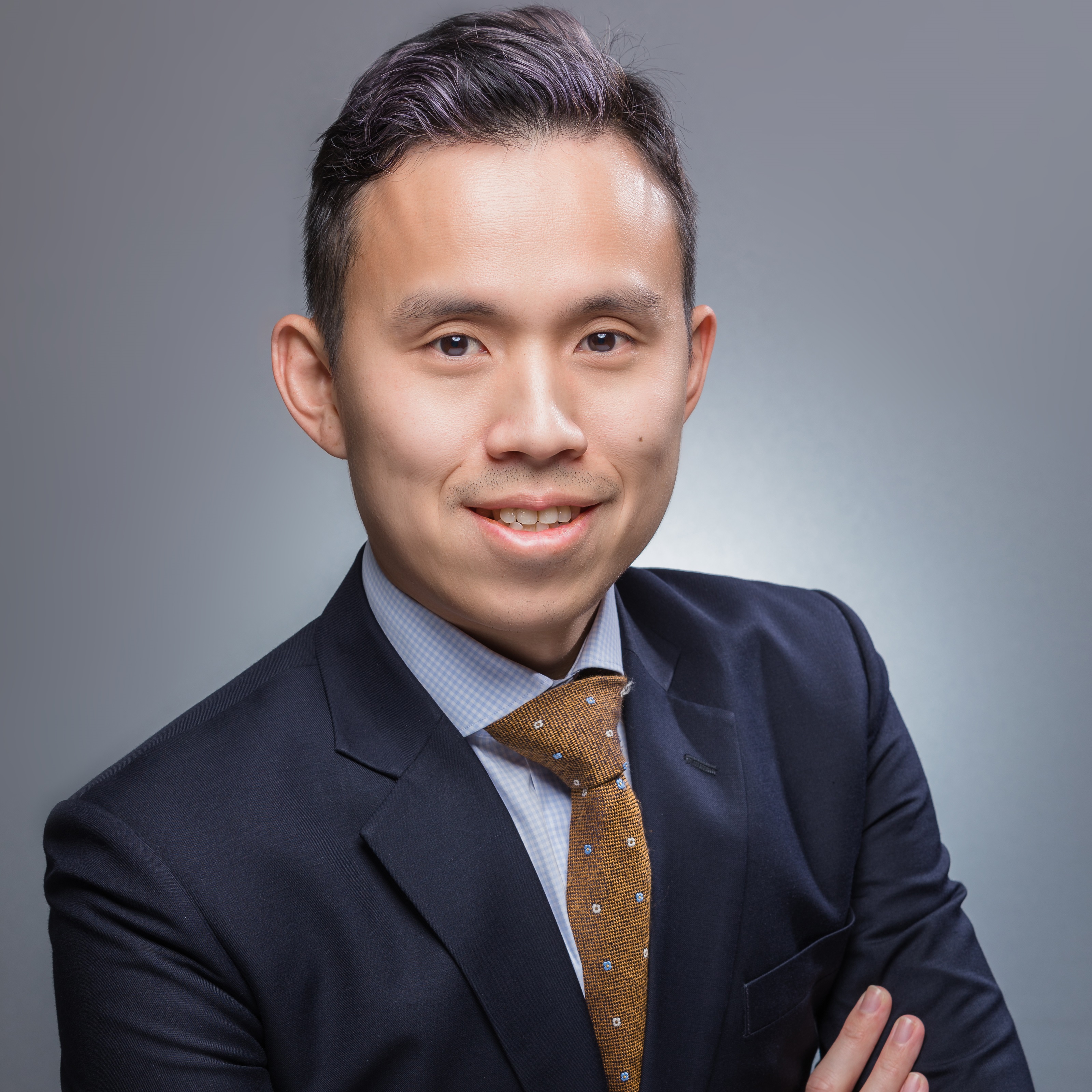 Person in a suit smiling at the camera.