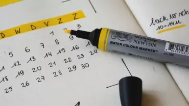 Open planner with a highlighted date and marker on top.