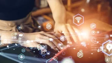 Person typing on a laptop surrounded by digital icons.
