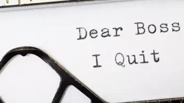 Close-up of a typed resignation note saying, 'Dear Boss, I Quit.'