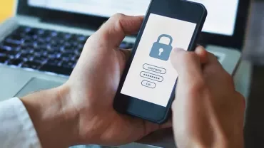 Person holding a smartphone displaying a security lock screen.