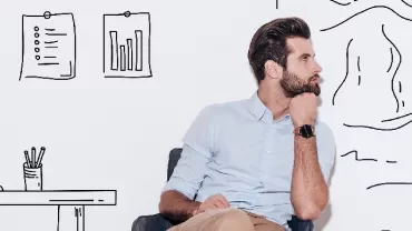 Man sitting pensively in front of a wall with sketched office decor and mountains.