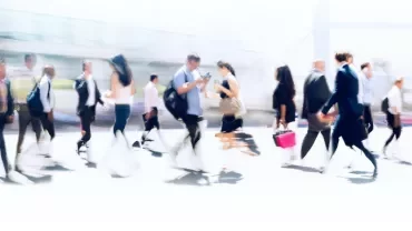Blurred image of people walking on a busy street.