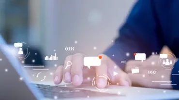 Person typing on laptop with graphic icons representing digital communication.