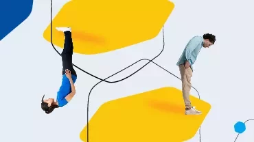 Person upside down on yellow shape, another standing upright.