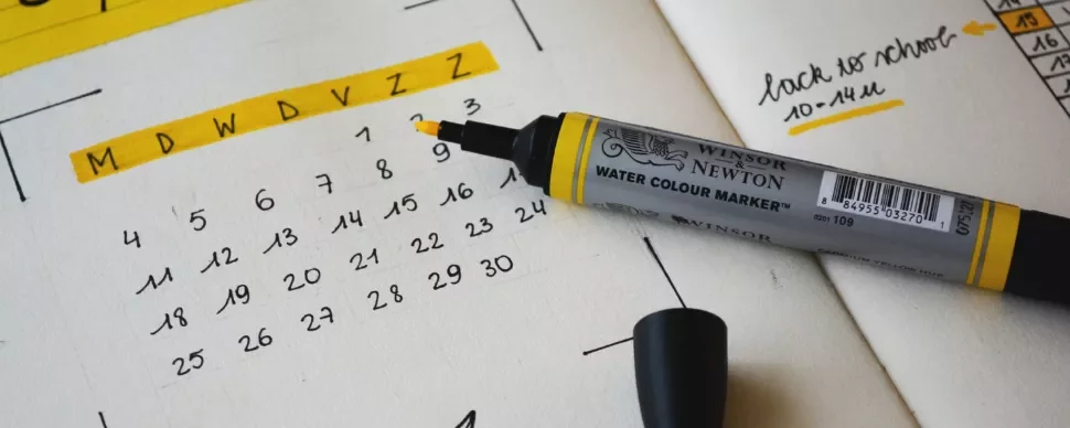 Open planner with a highlighted date and marker on top.