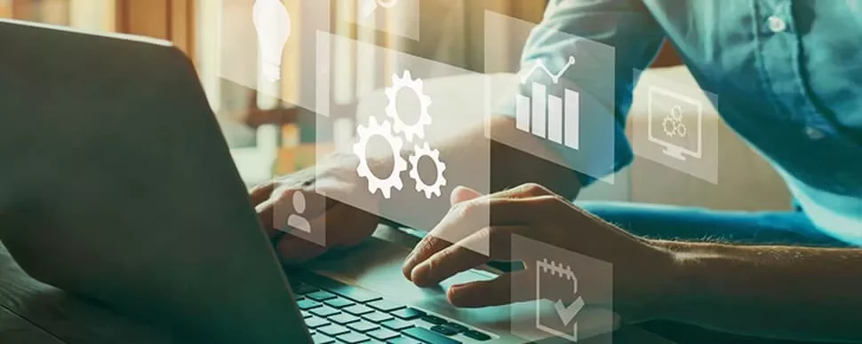 Person typing on laptop with virtual technology icons like gears and graphs.