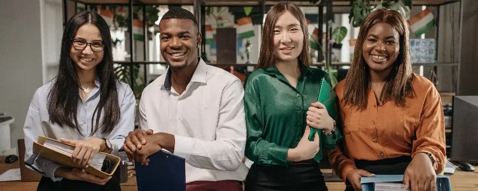 Three female and one male working professionals in an office setting